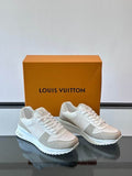 Premium monogram low-top sneakers in cream and off-white with grey suede accents, displayed with orange luxury box